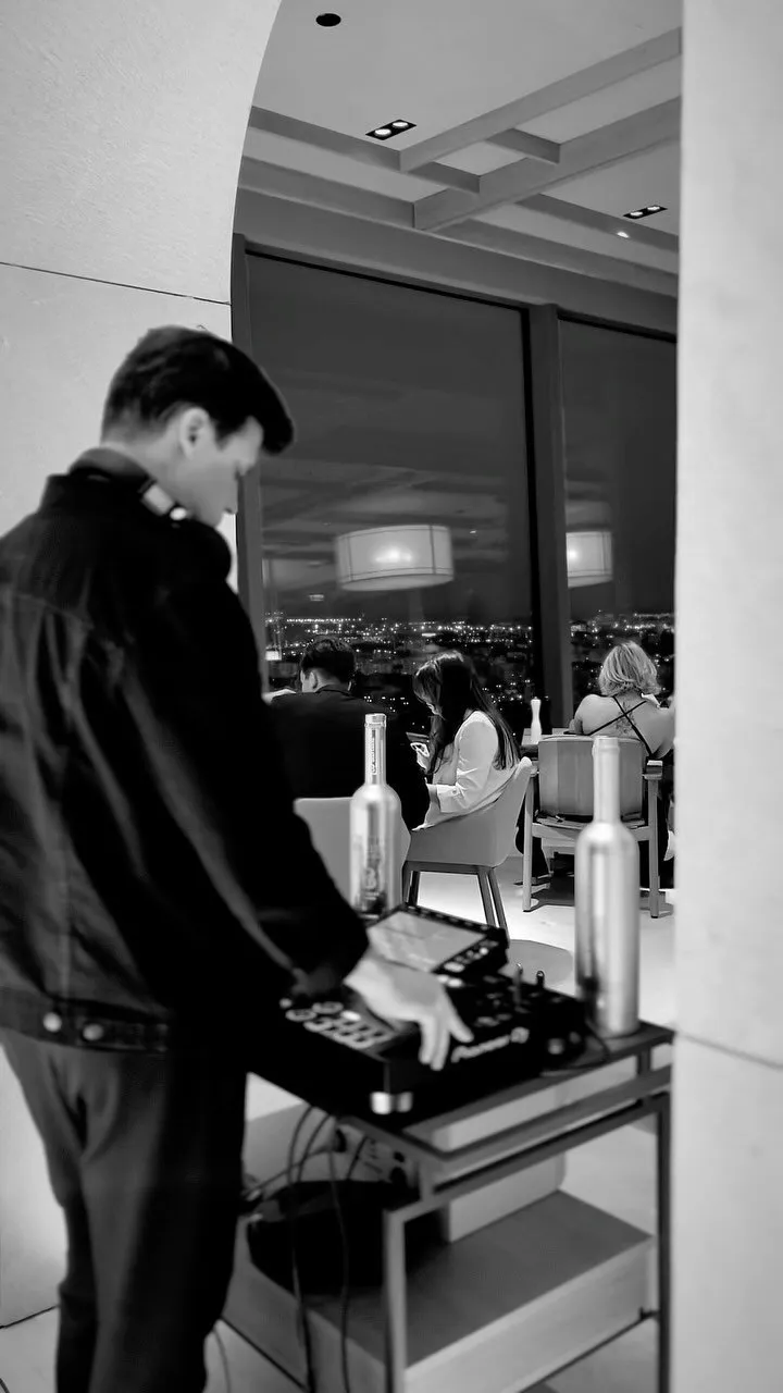Luke Erb playing a rooftop set above the Gdansk city lights, in black and white