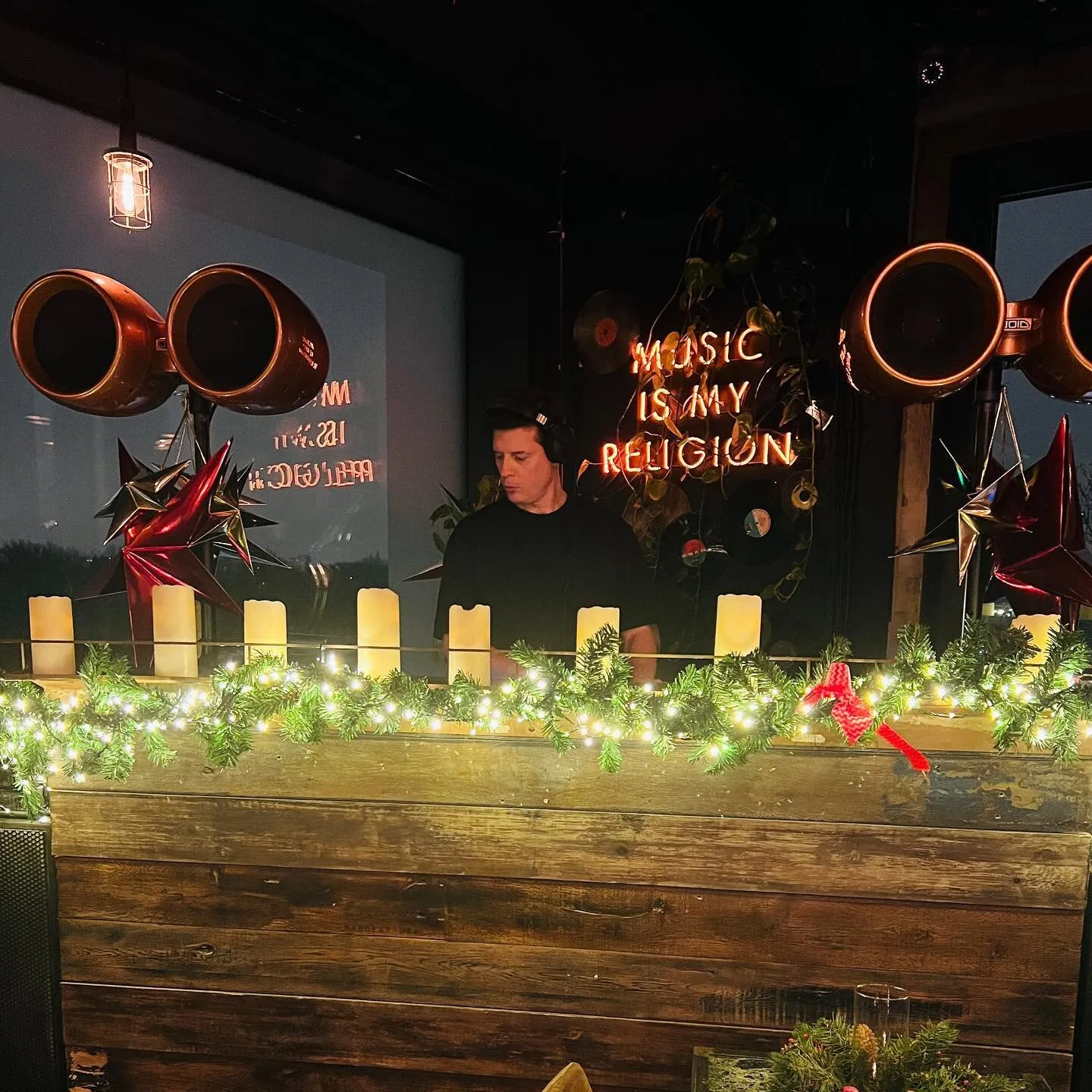 Luke Erb at SEN, Warsaw, under a neon sign reading Music Is My Religion